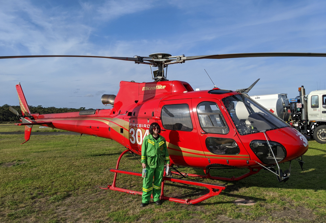 Erin Letovsky standing next to a helicopter