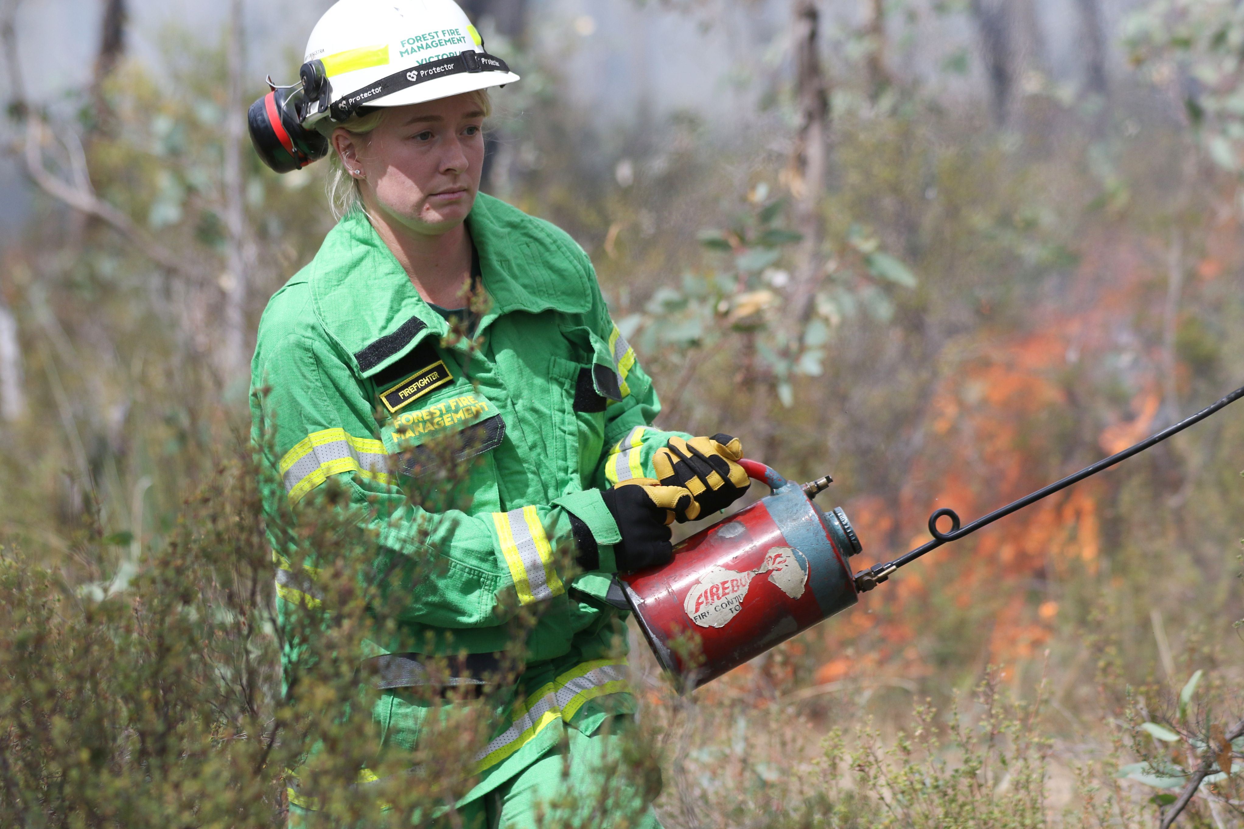 Woman with a drip torch doing a planned burn.