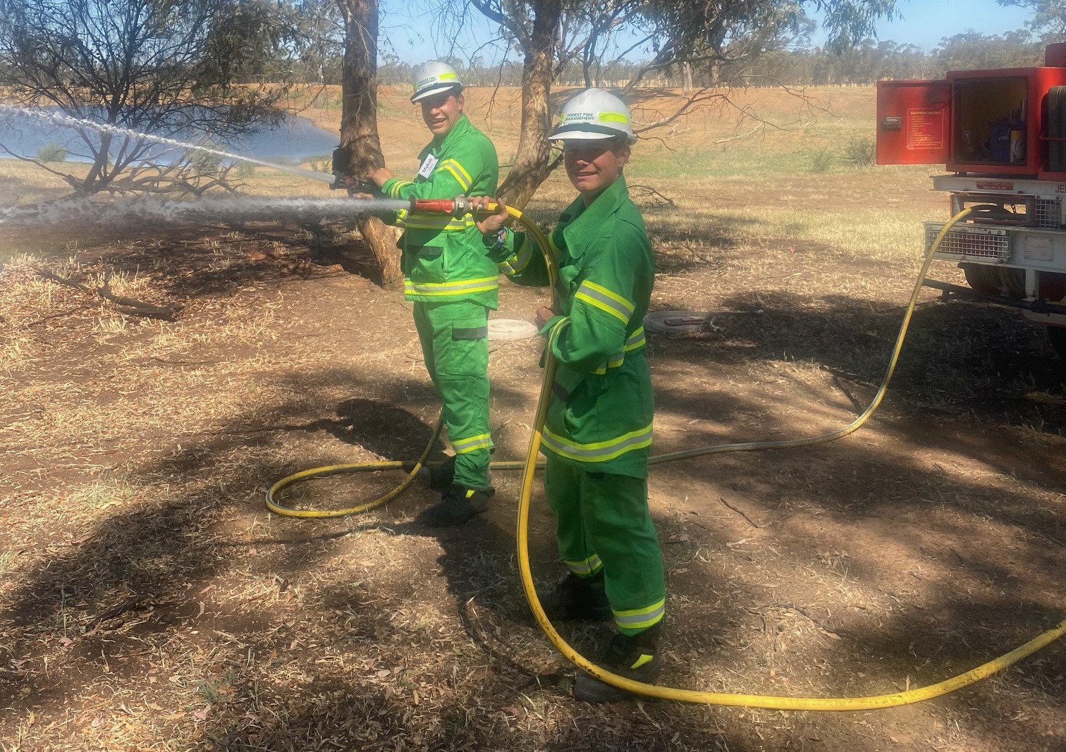 Two firefighter trainees with a hose