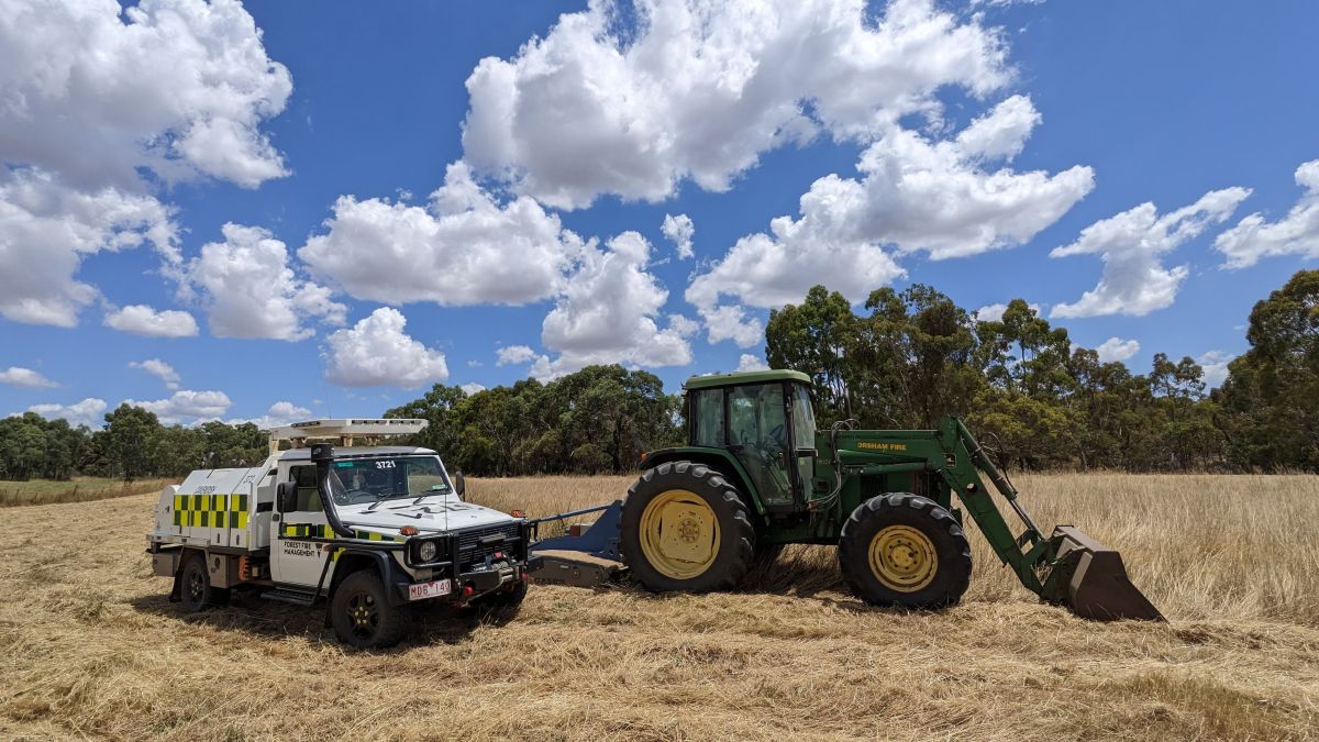 A FFMVic vehicle parked next to a tractor in public land