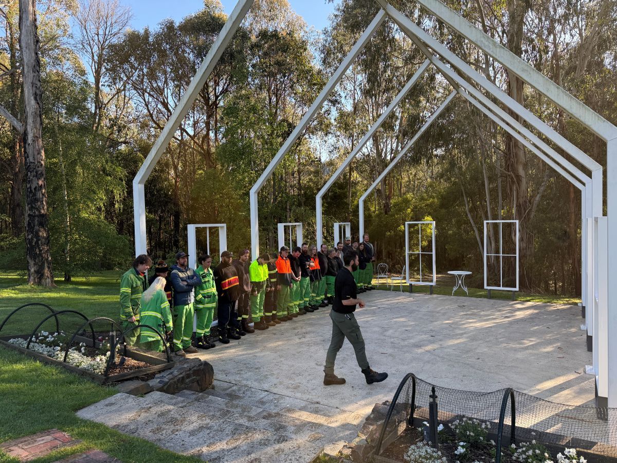 Trainees listening to one of the FFMVic trainers under a house-type frame