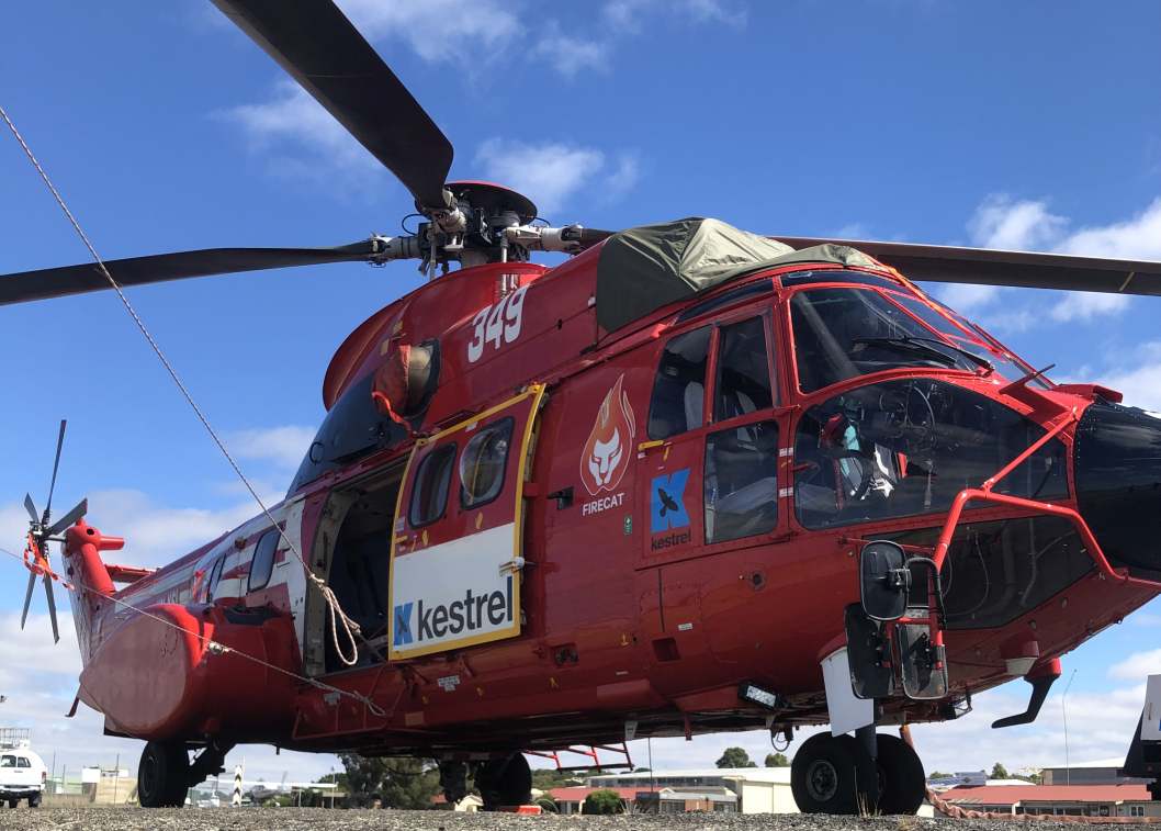 Super Puma helicopter dropping water on a grass fire