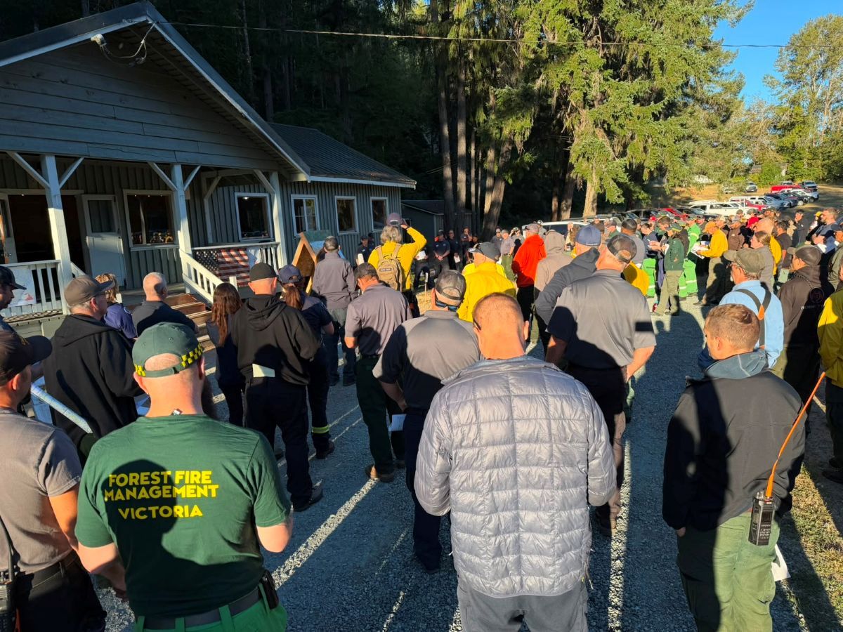 Firefighters gathered outside listening to a briefing ahead of operations
