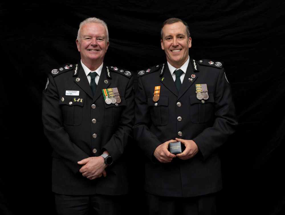 Aaron Kennedy receiving an award with Chris Hardman, both in uniform