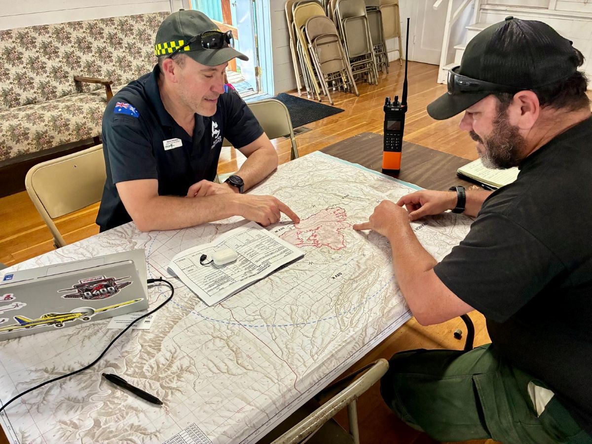 Aaron and a firefighter looking at a map on the table